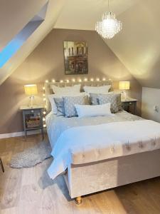 a bedroom with a large bed and a chandelier at Entire Loft Space in quiet village near Roman City of Lincoln in Lincoln