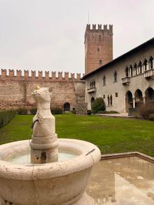 una fuente de piedra frente a un castillo en River Castle Central Verona en Verona