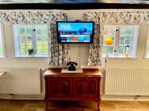 a living room with a flat screen tv and two windows at Ferienhäuser Armsen in Kirchlinteln