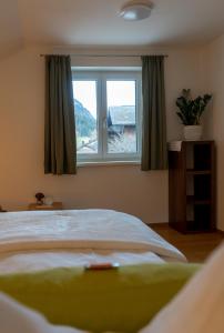 a bedroom with a large bed and a window at s`Hauserl 311 in Altaussee