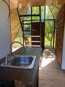 une cuisine avec un évier et une grande fenêtre dans l'établissement Queen house, à Nosara