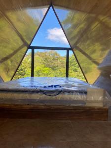 ein Bett in einem Zelt mit einem Fenster in der Unterkunft Queen house in Nosara