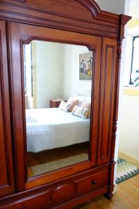 a bedroom with a large mirror in a wooden cabinet at Casa Mindela Farmhouse in Vila do Conde