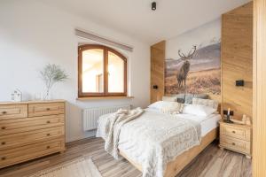 a bedroom with a bed and a painting of a deer at Apartamenty witów in Witów