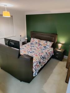 sypialnia z łóżkiem i zieloną ścianą w obiekcie A one spacious bedroom apartment w mieście Welling