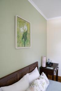 a bedroom with a bed and a picture on the wall at Casa Mindela Farmhouse in Vila do Conde