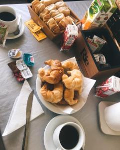 una mesa con un plato de bollería y una taza de café en Punta Gaviota Apart en Villa Gesell