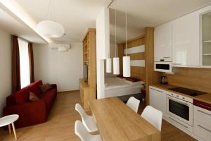 a kitchen and living room with a table and chairs at La Bella Centrum apartmanok Piros/Sárga in Hévíz