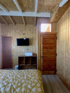 een slaapkamer met een bed en een flatscreen-tv bij Casa raíces in Cochrane