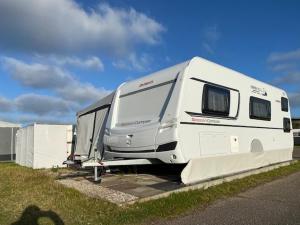 a white rv parked in a parking lot at Wohnwagenvermietung Sylt in Rantum