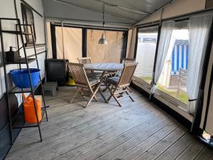 ein Esszimmer mit einem Tisch und Stühlen in einem Wohnwagen in der Unterkunft Wohnwagenvermietung Sylt in Rantum