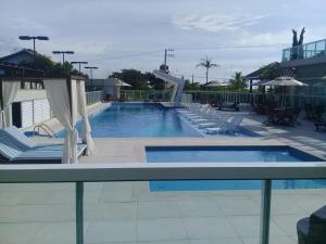 una gran piscina con tumbonas en Velutti Home Club - Conforto Lazer e Vista Pro Mar, en Penha