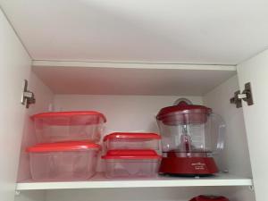 a kitchen with a red blender on a shelf at Apartamento Prainha Arraial in Arraial do Cabo +9 photos
