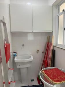 a small bathroom with a toilet and a sink at Apartamento Prainha Arraial in Arraial do Cabo +9 photos