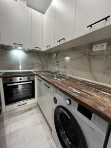 uma cozinha com uma máquina de lavar roupa e um lavatório em Modern flat Ag. Dimitriou em Tessalônica