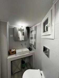 uma casa de banho branca com um lavatório e um WC em Modern flat Ag. Dimitriou em Tessalônica