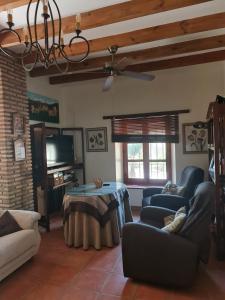 a living room with couches and a table and a television at LOS CORRALILLOS in Motril