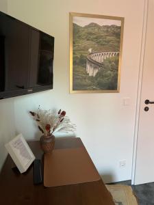 Zimmer mit einem Tisch und einem Gemälde einer Brücke in der Unterkunft Gasthof Strietholt in Everswinkel