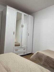 um quarto com um armário branco e uma cama em Дизайнерская трехкомнатная квартира em Karaganda