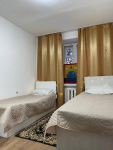 um quarto com 2 camas e uma janela em Дизайнерская трехкомнатная квартира em Karaganda