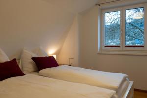 two beds in a room with a window at s`Hauserl 311 in Altaussee