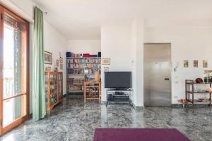 een woonkamer met een flatscreen-tv en een woonkamer met een groot raam bij La casa di Dani in Florence
