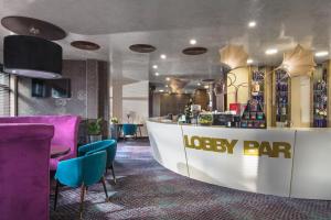 a lobby with a lobby bar with purple chairs at Ores Boutique Hotel in Bansko
