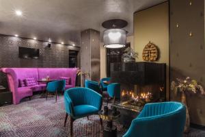 a room with a fireplace and a purple couch at Ores Boutique Hotel in Bansko +65 photos