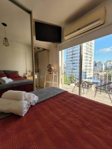 1 dormitorio con 1 cama grande y ventana grande en Luminoso y cómodo departamento con balcón en Buenos Aires