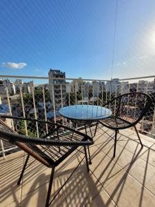 - Balcón con mesa y sillas y vistas a la ciudad en Luminoso y cómodo departamento con balcón en Buenos Aires