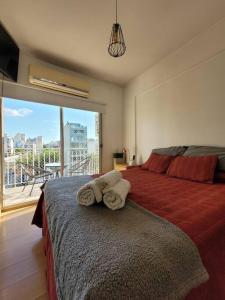 1 dormitorio con 1 cama con 2 toallas en Luminoso y cómodo departamento con balcón en Buenos Aires