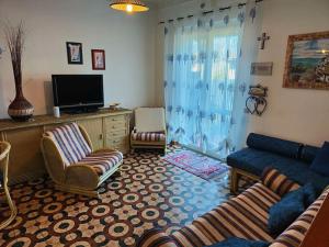 sala de estar con sofá, sillas y TV en Ridente villetta a schiera, 10min a piedi dal mare, en San Felice Circeo