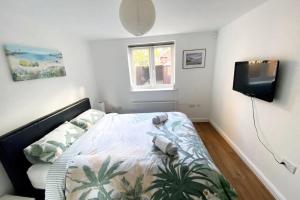 1 dormitorio con 1 cama y TV en Modern & Stylish 2 Bedroom Apartment! - Ground Floor - FREE Parking for 2 Cars - Netflix - Disney Plus - Sky Sports - Gigabit Internet - Newly decorated - Sleeps up to 5! - Close to Bournemouth Train Station, en Bournemouth