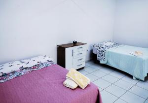 1 dormitorio con 2 camas y vestidor con toallas en Ikigai Brasil Houses, en Foz do Iguaçu