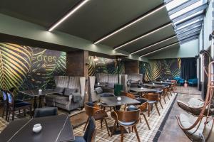 a restaurant with tables and chairs and plants at Ores Boutique Hotel in Bansko
