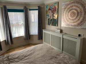 ein Schlafzimmer mit einem Bett und einem Wandgemälde in der Unterkunft Relaxing home - 7-10min to Bournemouth sandy beach by car - private garden, parking and spa in Bournemouth