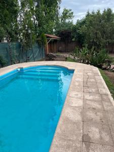 a swimming pool with blue water in a yard at Casa en Chacras de Coria - zona de Bodegas in Ciudad Lujan de Cuyo