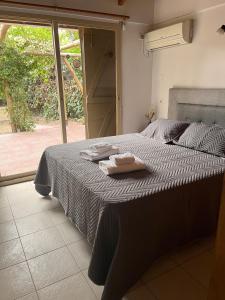 1 dormitorio con 1 cama con 2 toallas en La Oma. Casa en Chacras de Coria en Luján de Cuyo