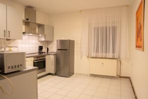a kitchen with a refrigerator and a microwave at Haus Kim Thinh in Betzdorf