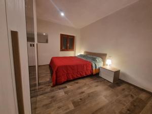 - une chambre avec un lit doté d'un couvre-lit rouge et d'une porte en verre dans l'établissement La casetta di Maty&Fra, à Pistoia