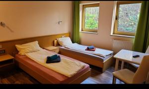 Habitación con 2 camas, mesa y 2 ventanas. en Hotel Neue Krone, en Markt Erlbach
