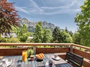 einen Tisch mit einer Schüssel Essen auf einem Balkon mit Bergblick in der Unterkunft LA BECCAZ in Montmin