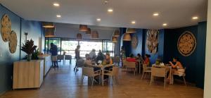 a group of people sitting at tables in a restaurant at Praia dos Carneiros Flat 120-CM Eco Resort - ao lado da igrejinha in Tamandaré