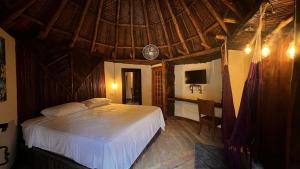 a bedroom with a bed in a room with a roof at Tawaca ecohotel in Santa Marta