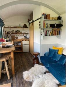 ein Wohnzimmer mit einem blauen Sofa und einem Tisch in der Unterkunft Pilgrims Nap in Rainham