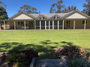 a large house with a large yard with flowers at Woodside Ranch Luxury Farmstay in Woodside