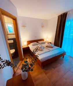 um quarto com uma cama king-size e uma casa de banho em Apartments Stina em Seget Vranjica