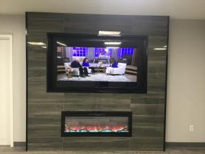 TV de pantalla plana en la pared con chimenea en Americas Best Value Inn Muskogee, en Muskogee