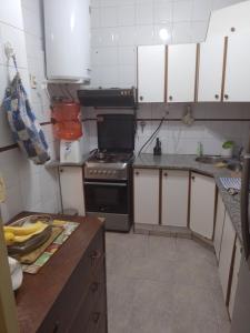 cocina con armarios blancos y fogones en La casa de Lukita en Buenos Aires