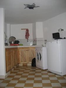 Appartement dans la médina في أصيلة: مطبخ مع ثلاجة بيضاء وغسالة ملابس
